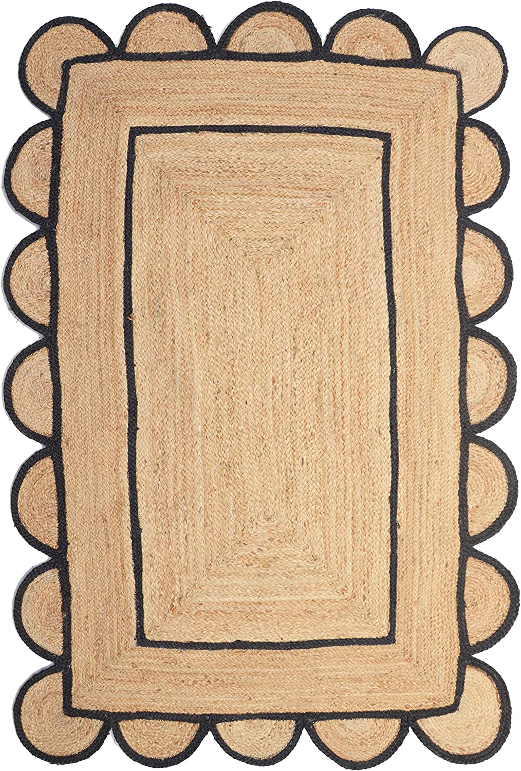 Handwoven natural jute area rug with black scalloped border in a modern Scandinavian living room featuring a cream sofa, wooden chair, and light wood flooring.