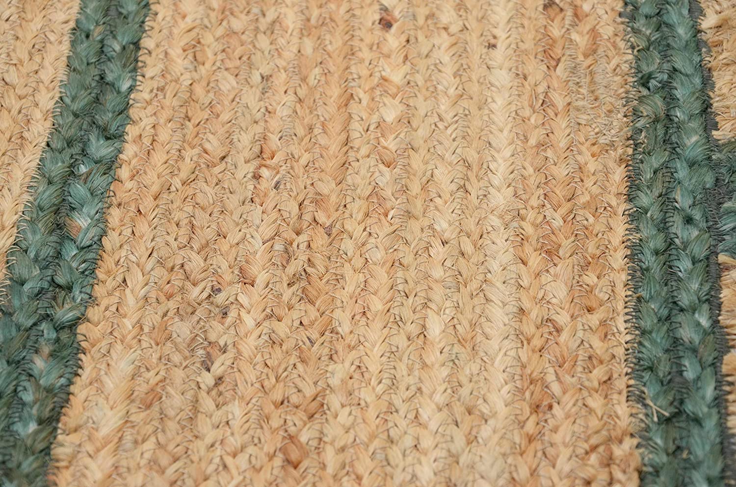 Handwoven natural jute area rug with green scalloped border placed in a modern Scandinavian living room featuring sustainable eco-friendly braided craftsmanship.