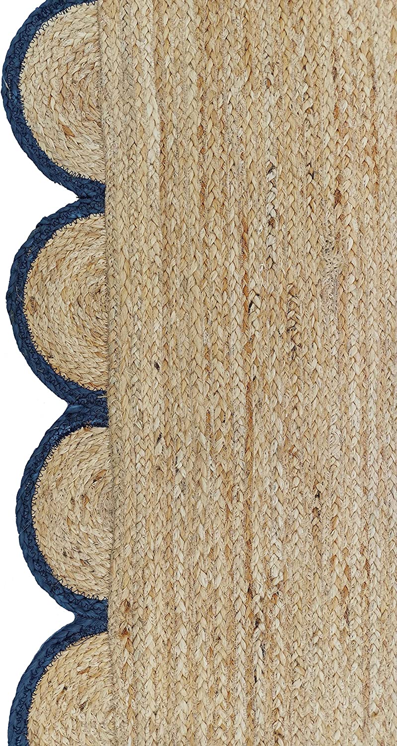 Handmade natural jute scalloped border area rug with blue trim in a bright farmhouse style living room.