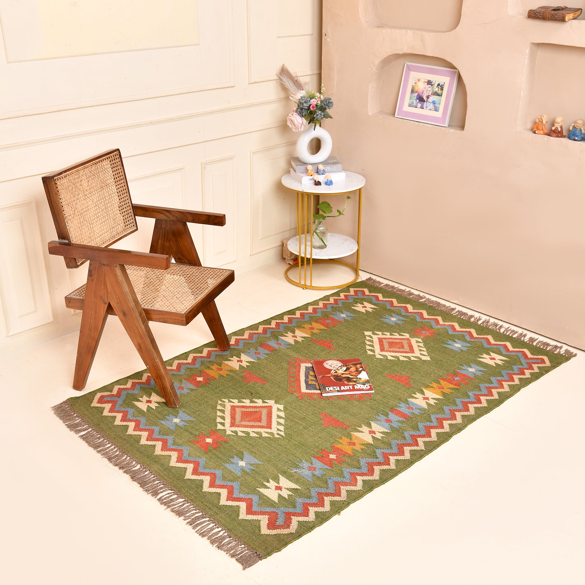 Handwoven Green Kilim Area Rug with colorful tribal geometric pattern made from wool and cotton, styled in a modern living room with wooden chair and side table.