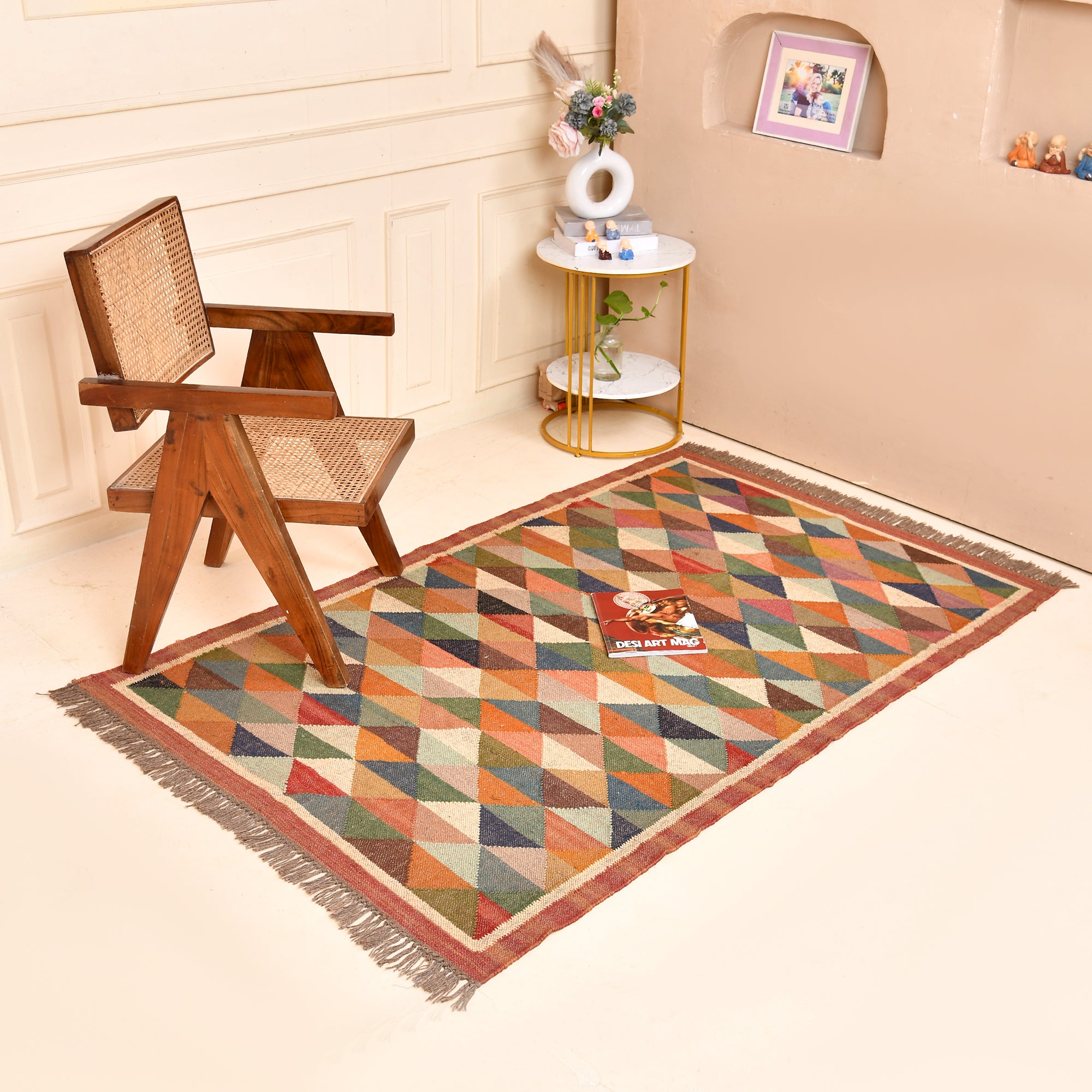 Handwoven terracotta diamond Kilim area rug with geometric tribal design, handmade from wool and cotton, styled in a modern living room with a wooden accent chair and side table.