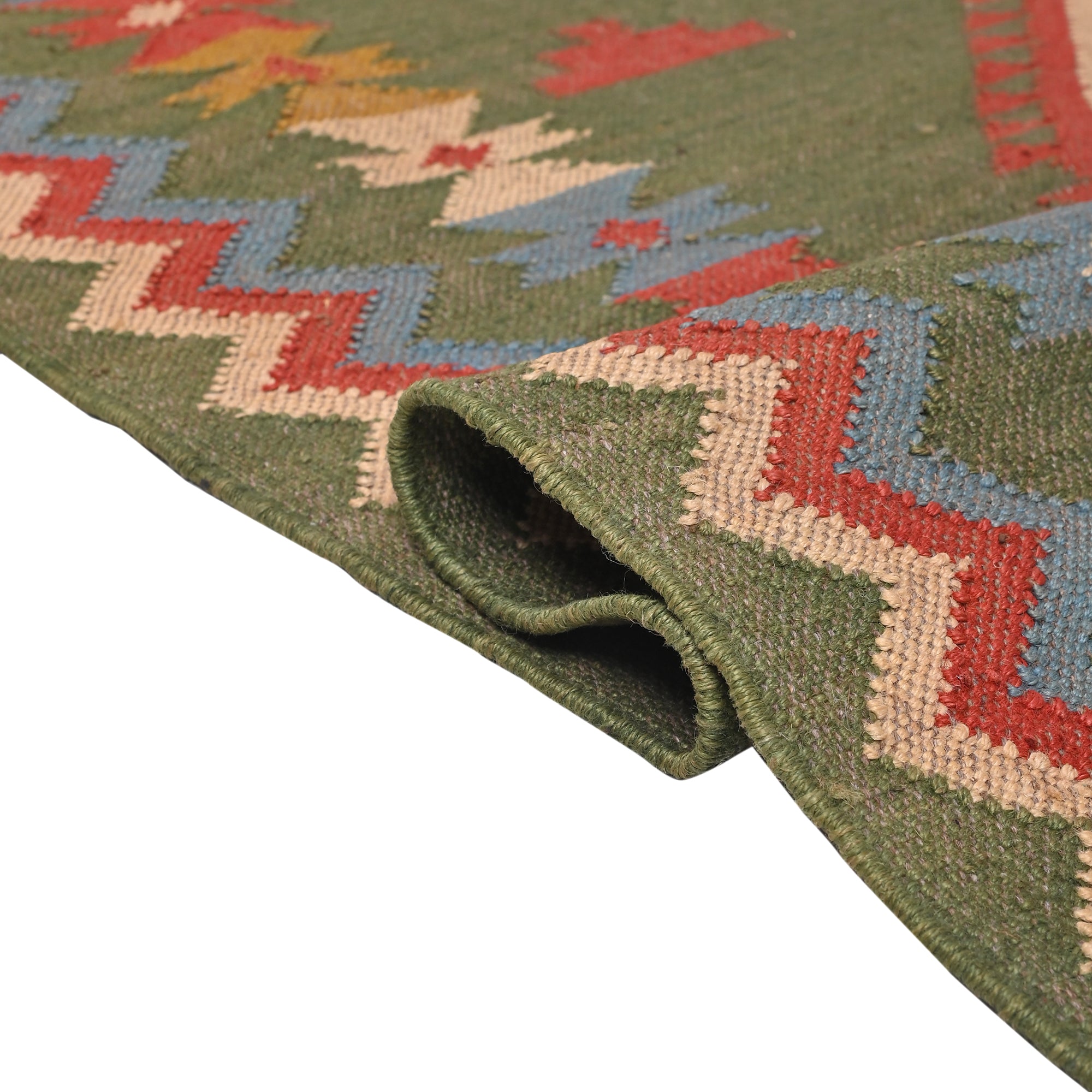 Handwoven Green Kilim Area Rug with colorful tribal geometric pattern made from wool and cotton, styled in a modern living room with wooden chair and side table.