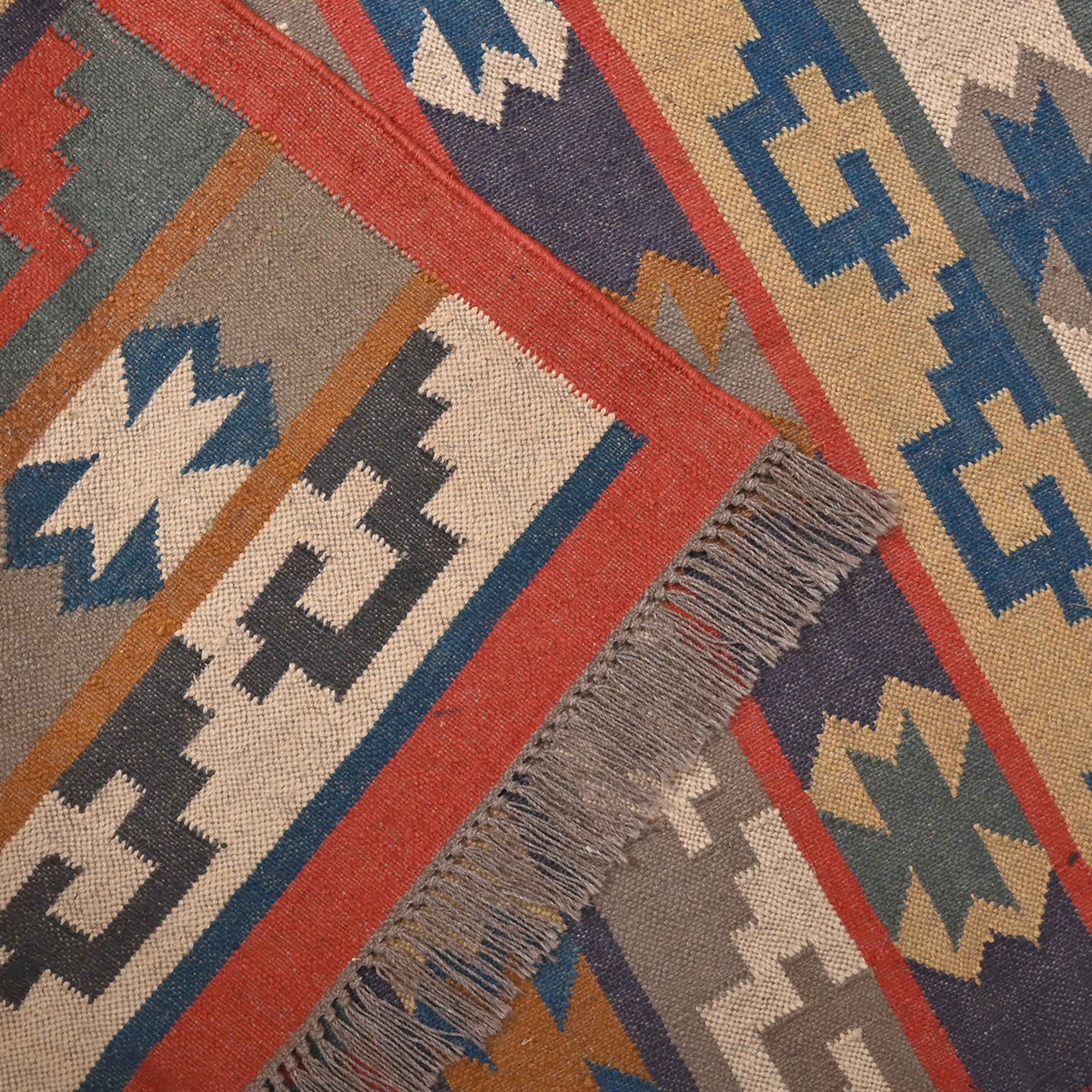 Handwoven Southwestern Kilim wool cotton area rug with colorful tribal geometric pattern in a modern living room.