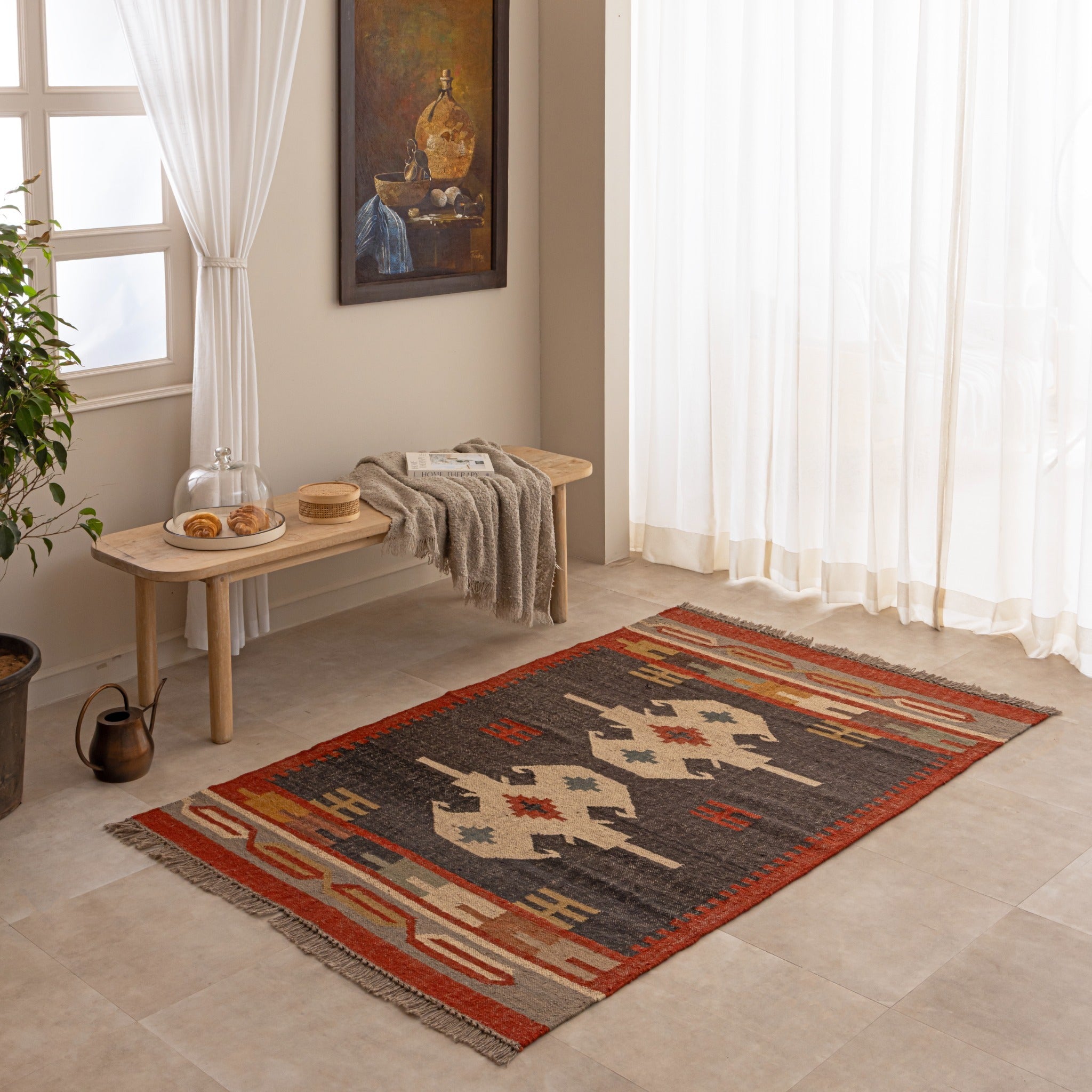 Handmade Southwestern tribal wool rug with geometric pattern in red, black, beige and mustard tones displayed in a cozy living room.