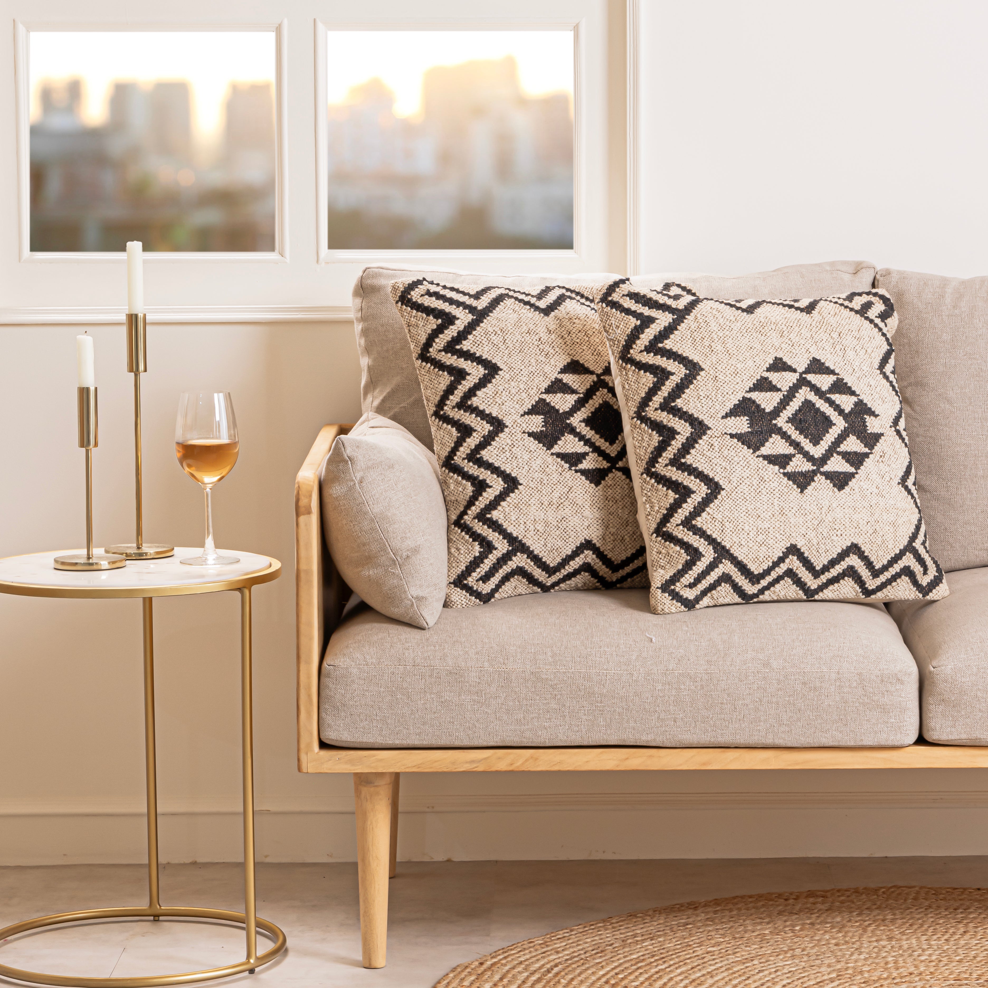 Handwoven black and ivory Kilim cushion cover featuring a geometric tribal diamond pattern displayed in a modern minimalist home setting.
