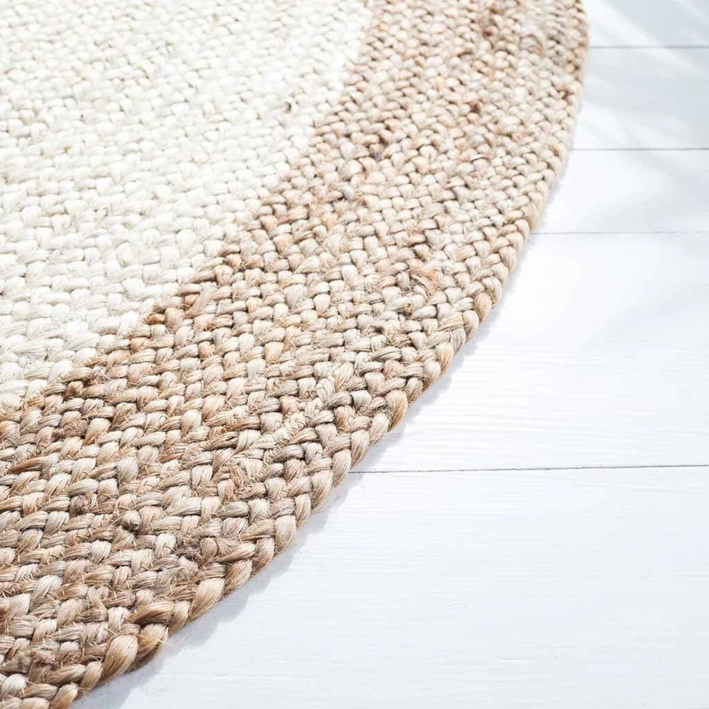 Handmade natural jute and ivory round rug with braided texture in a cozy neutral boho living room with a wooden coffee table and beige sofa.