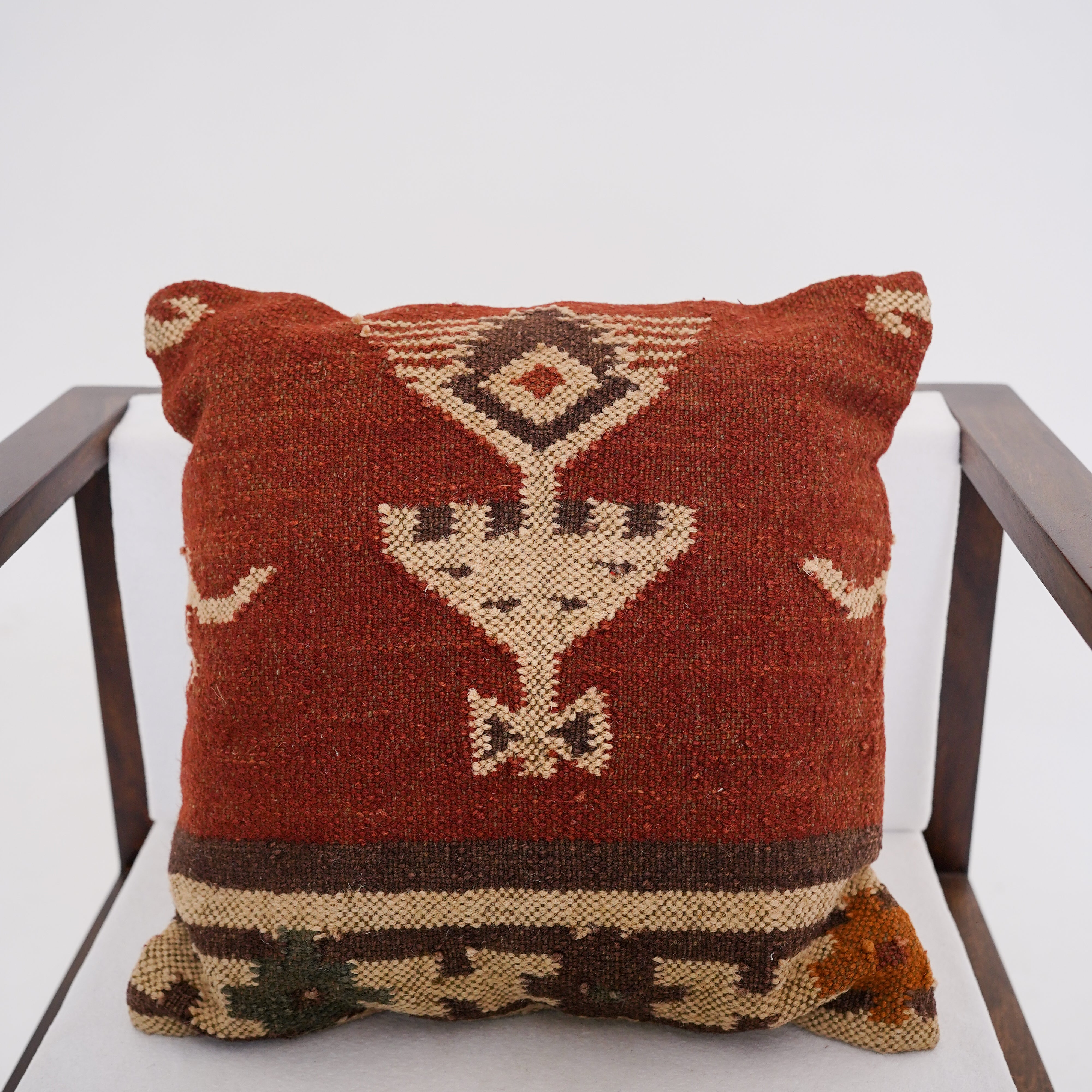 Handwoven rust red wool Kilim cushion cover featuring an ivory Southwestern tribal motif, handmade decorative throw pillow for boho, farmhouse, rustic, and modern home décor.