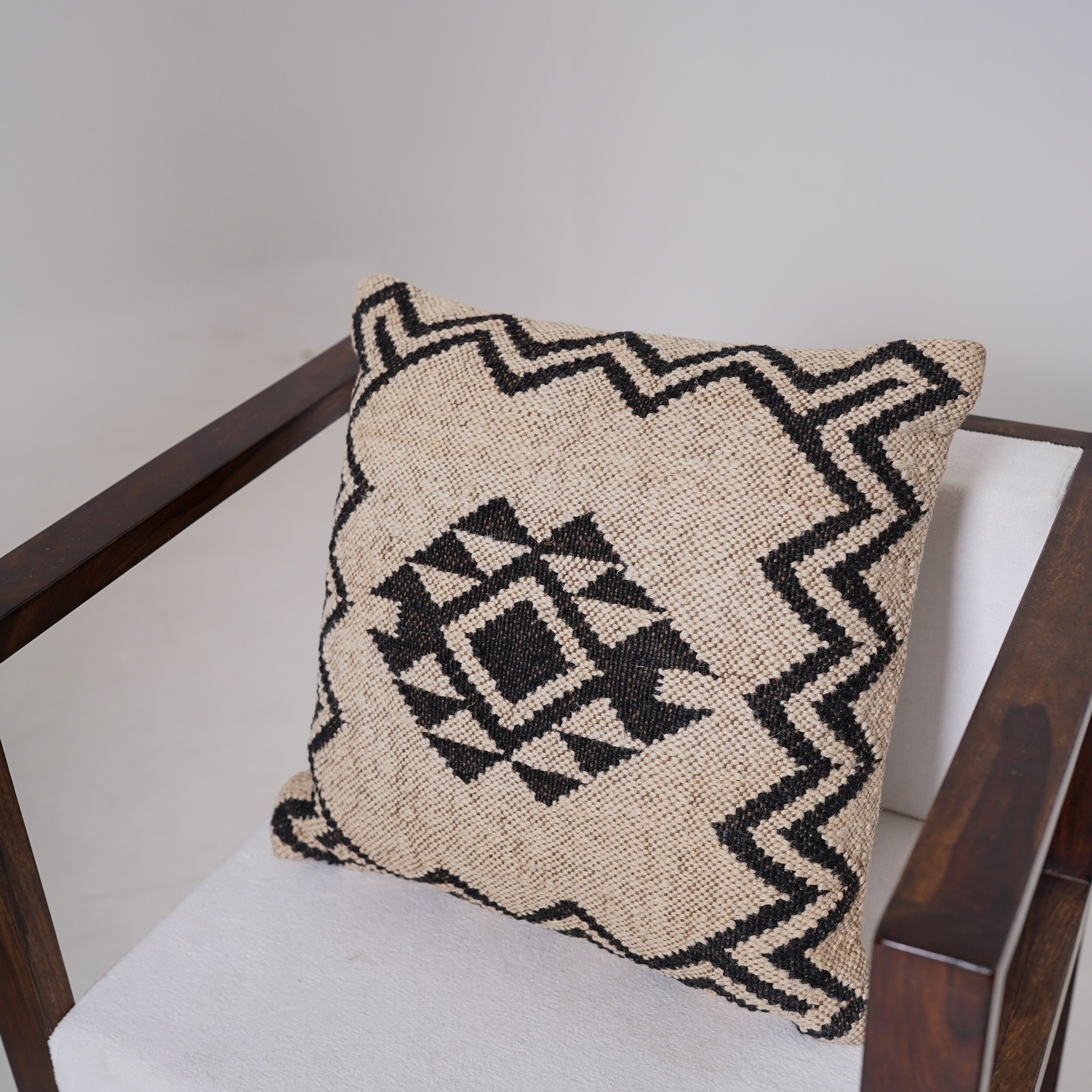 Handwoven black and ivory geometric cotton cushion cover with tribal diamond pattern for boho farmhouse living room décor.